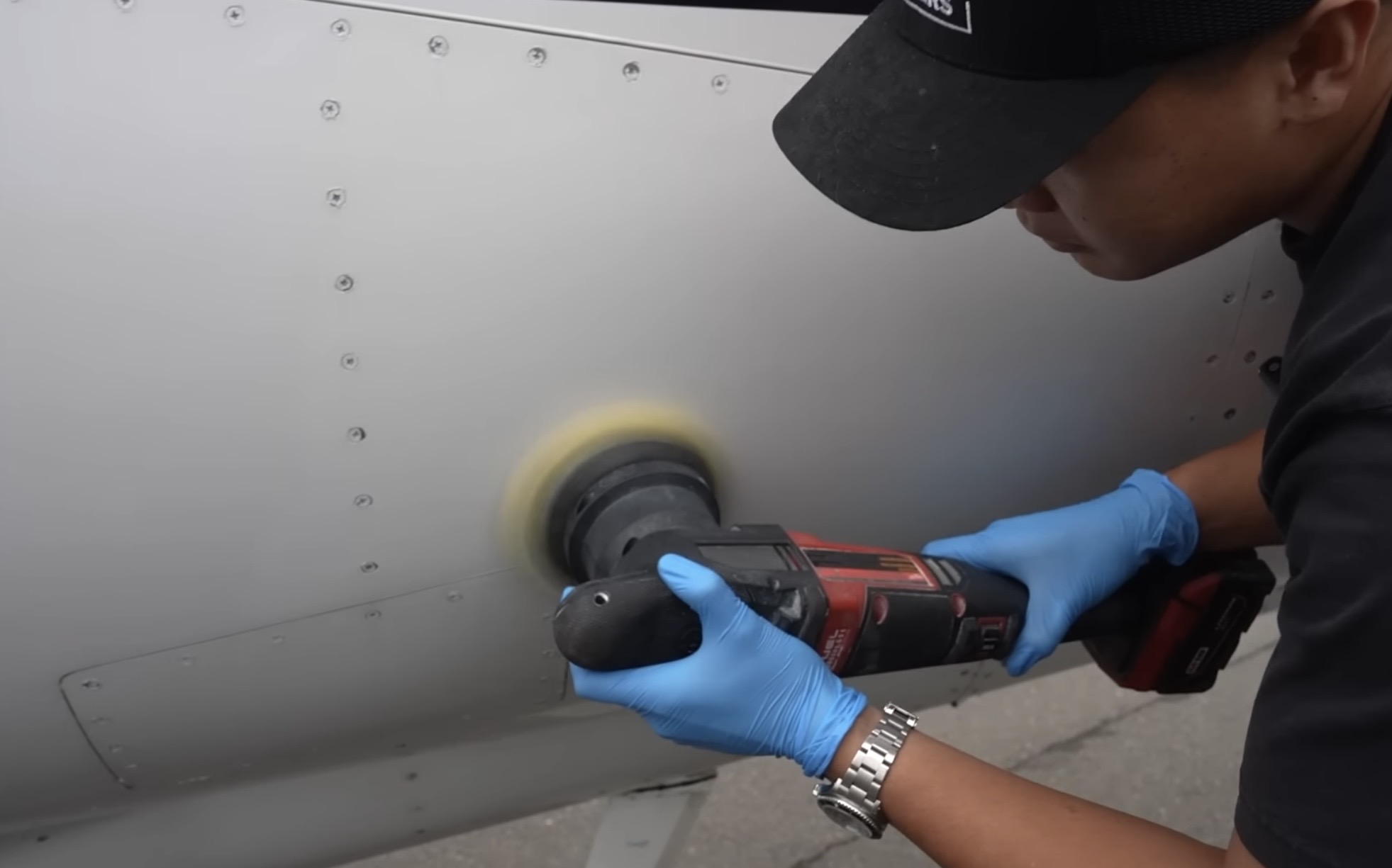 Machine polishing an aircraft fuselage panel during paint correction